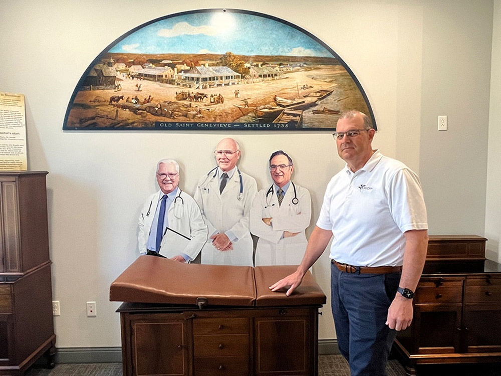 Pautler standing in front of exhibit with doctor cutouts